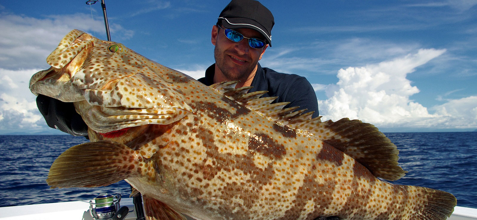 Man holding fresh caught grouper for Gandy Seafood Cajun Market Franchises